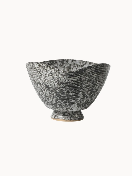 Ceramiczna miska, pokryta nakrapianą czarno-białą strukturą z poziomymi prążkami, na jednolitym białym tle. Miska ma unikalny, lekko kwadratowy, wygięty brzeg.